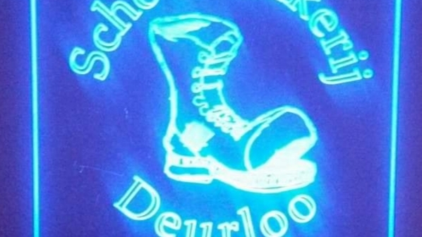 Het verlichte bord met het laarzen-logo van Schoenmakerij Deurloo